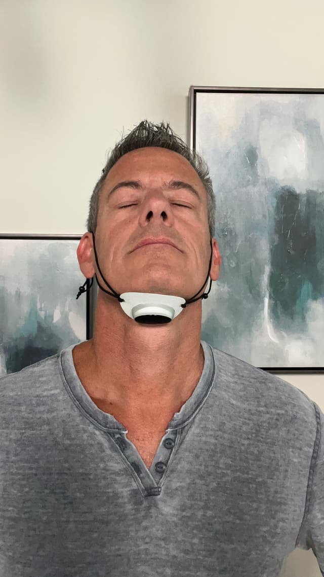 Man wearing the SleepEase Pro device under his chin